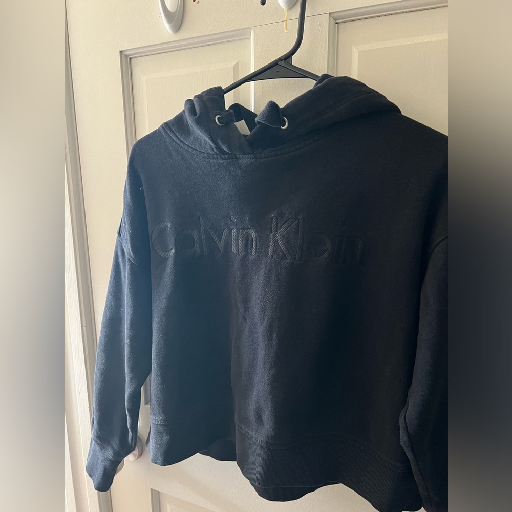 Black Calvin Klein hoodie with black stitching for letters, size small.